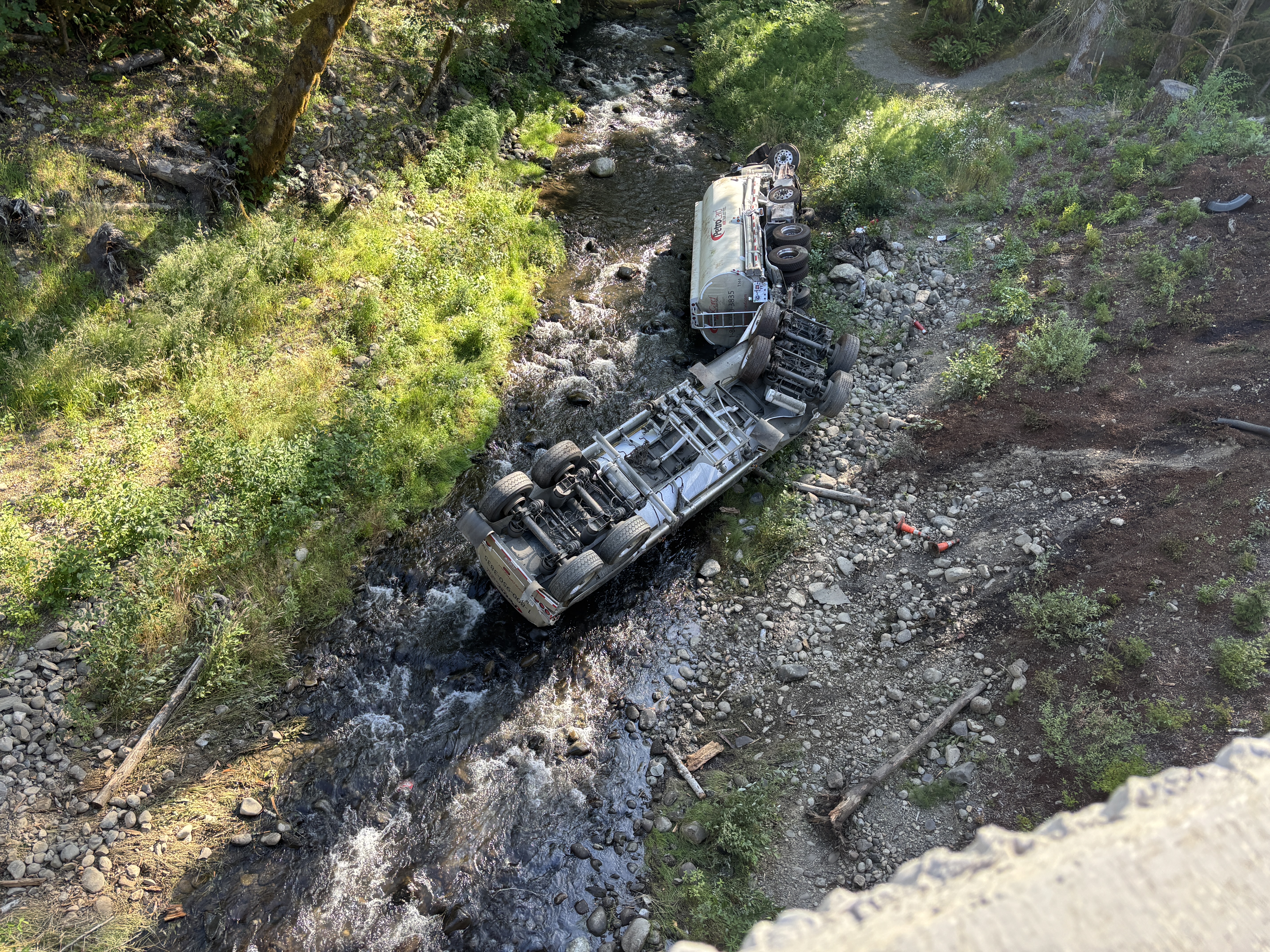 Aerial view of a semi truck turned over in Indian Creek WA discharging petroleum products into the watershed. 